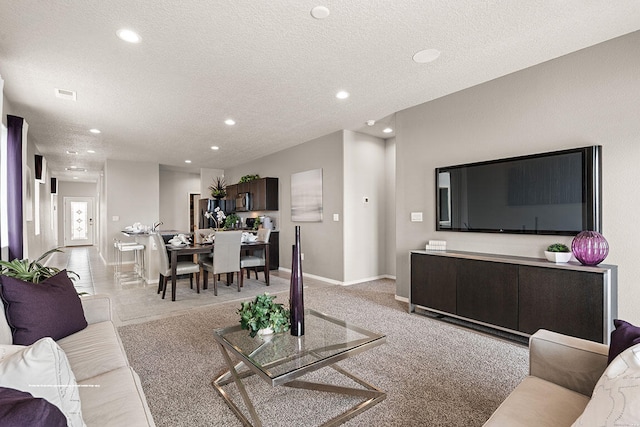 carpeted living room featuring a textured ceiling