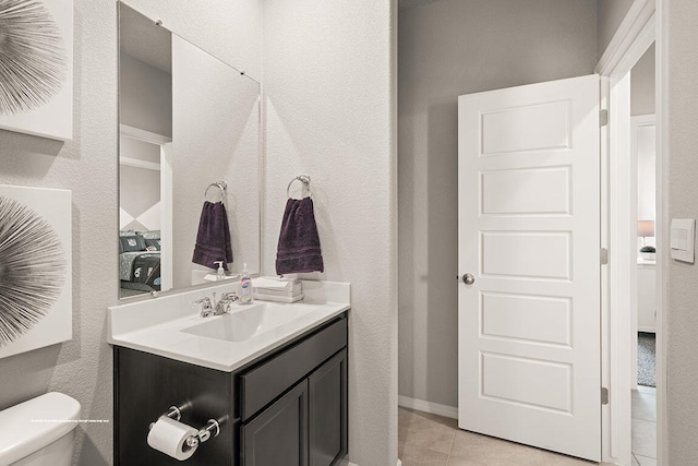 bathroom featuring tile patterned flooring, vanity, and toilet