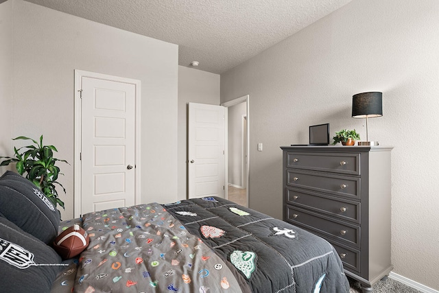 bedroom with carpet floors and a textured ceiling