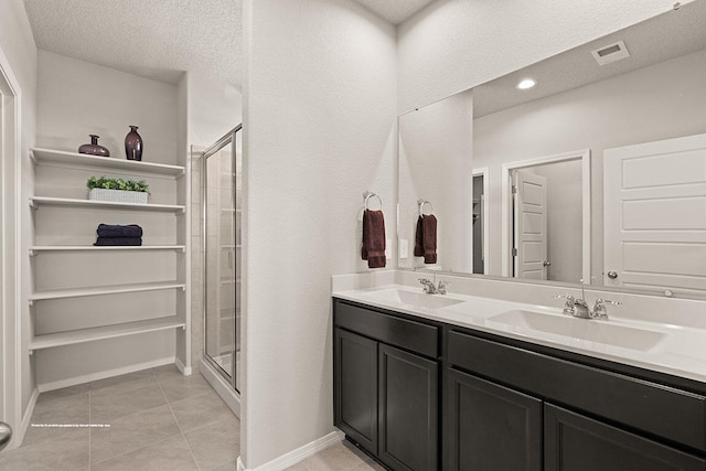 bathroom with vanity, a textured ceiling, tile patterned floors, and walk in shower