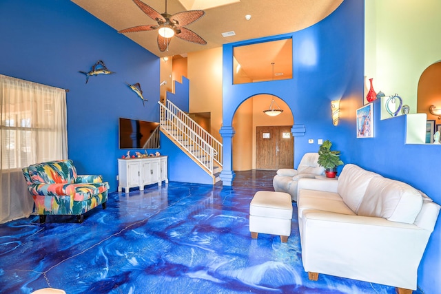 living room with ceiling fan, a textured ceiling, and high vaulted ceiling