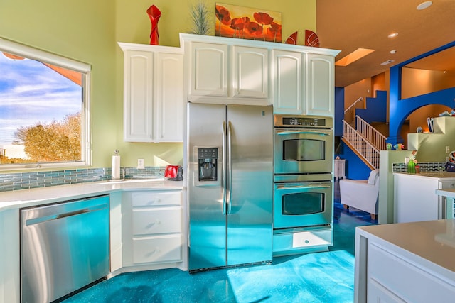 kitchen featuring white cabinetry, stainless steel appliances, a warming drawer, and light countertops