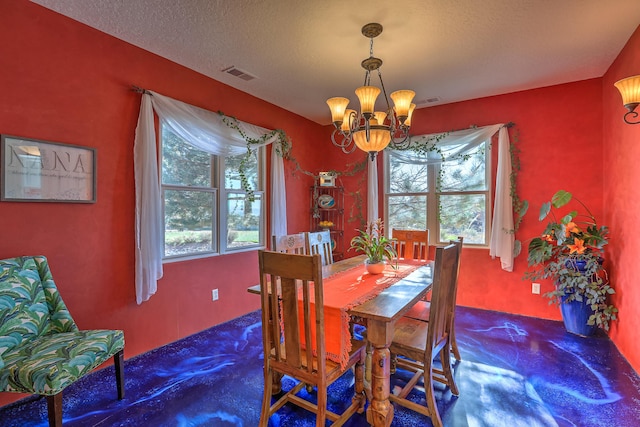 dining room featuring a textured ceiling, visible vents, and a notable chandelier