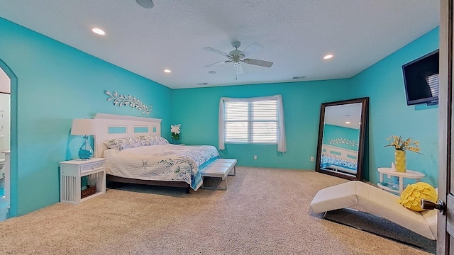 carpeted bedroom featuring arched walkways, a textured ceiling, a ceiling fan, and recessed lighting