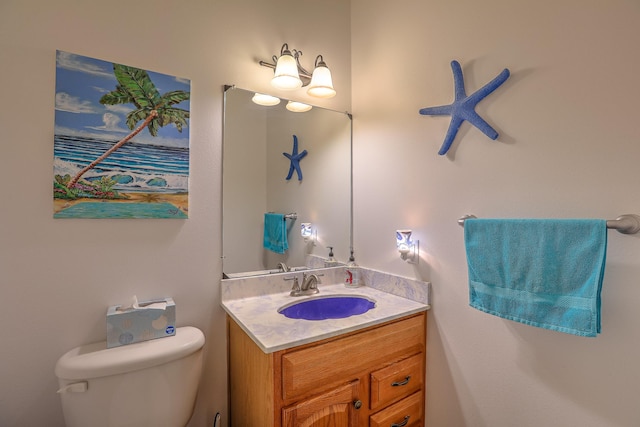 half bathroom with vanity and toilet