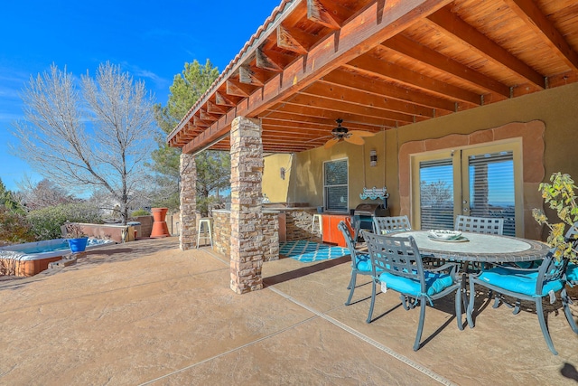 view of patio featuring an outdoor hot tub, area for grilling, a ceiling fan, outdoor dining space, and outdoor wet bar