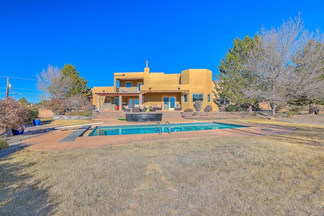 pool featuring an outdoor hangout area, a yard, a patio, and a diving board