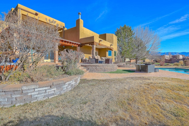 exterior space with a mountain view, outdoor lounge area, a fenced in pool, and a patio