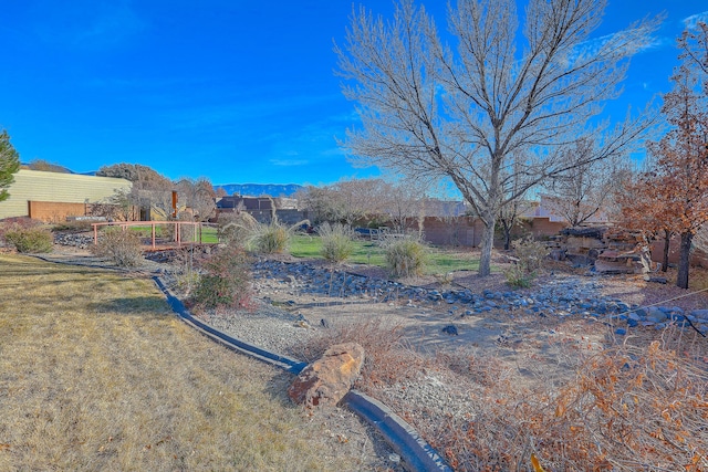 view of yard featuring fence and a mountain view