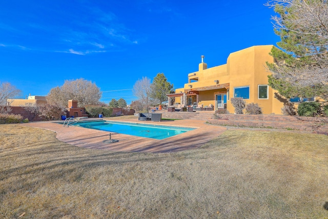 view of swimming pool featuring a yard, a patio area, and a fenced in pool