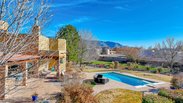 outdoor pool featuring a patio area and a mountain view