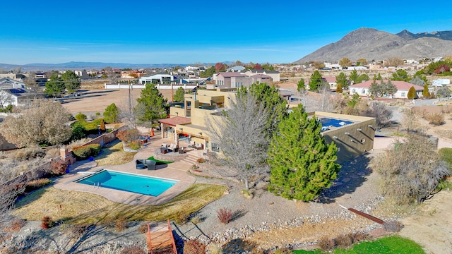 view of pool featuring a residential view, a fenced backyard, a mountain view, and a patio