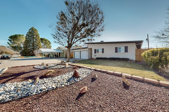 ranch-style home with a carport, a garage, and a front yard