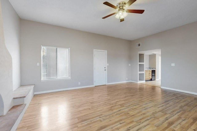 unfurnished living room featuring ceiling fan and light wood-type flooring