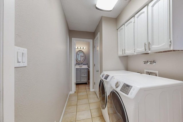 laundry area with washer and dryer, light tile patterned flooring, and cabinets