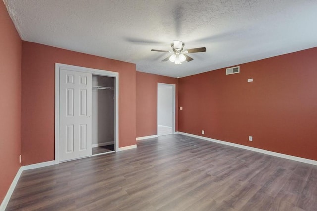 unfurnished bedroom with hardwood / wood-style flooring, ceiling fan, and a textured ceiling