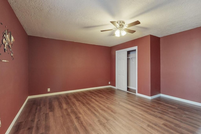 unfurnished bedroom featuring a closet, ceiling fan, hardwood / wood-style floors, and a textured ceiling