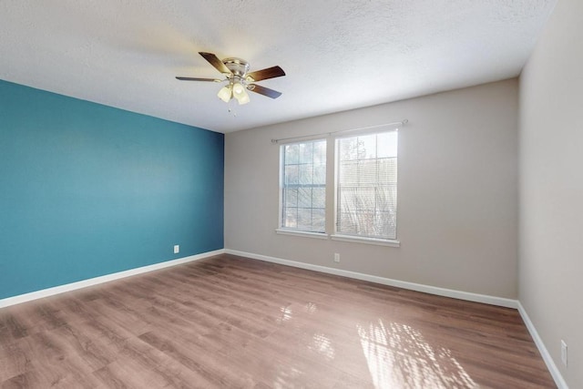 unfurnished room featuring hardwood / wood-style flooring, ceiling fan, and a textured ceiling