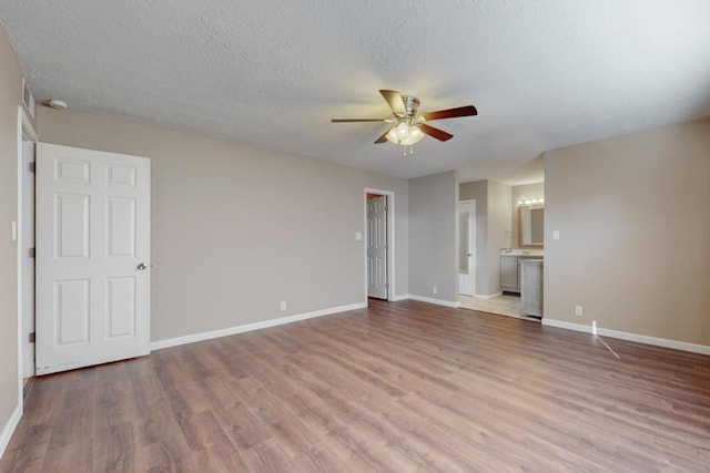 unfurnished room featuring ceiling fan, light wood-type flooring, and a textured ceiling