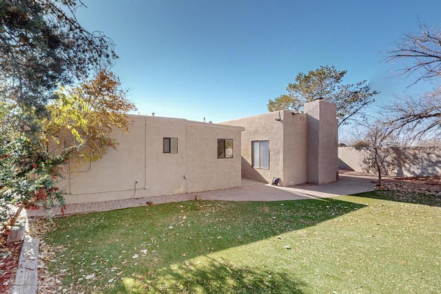 rear view of property featuring a yard and a patio