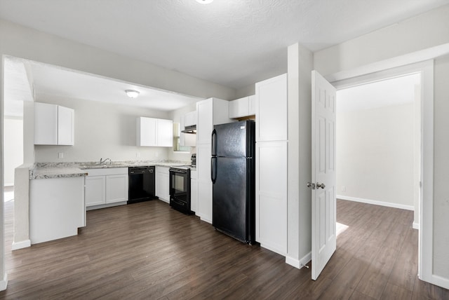 kitchen with sink, dark hardwood / wood-style floors, white cabinetry, and black appliances