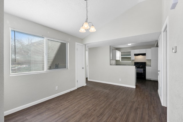 unfurnished living room featuring a textured ceiling, an inviting chandelier, dark wood-type flooring, and vaulted ceiling