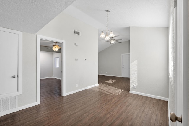 unfurnished room featuring a textured ceiling, ceiling fan with notable chandelier, dark wood-type flooring, and lofted ceiling