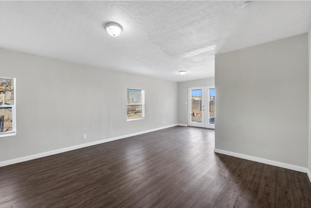 unfurnished room featuring french doors, dark hardwood / wood-style flooring, and a textured ceiling