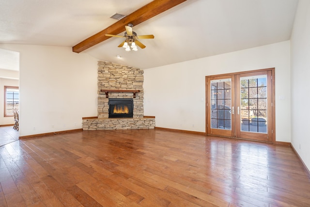 unfurnished living room featuring lofted ceiling with beams, a healthy amount of sunlight, and wood-type flooring