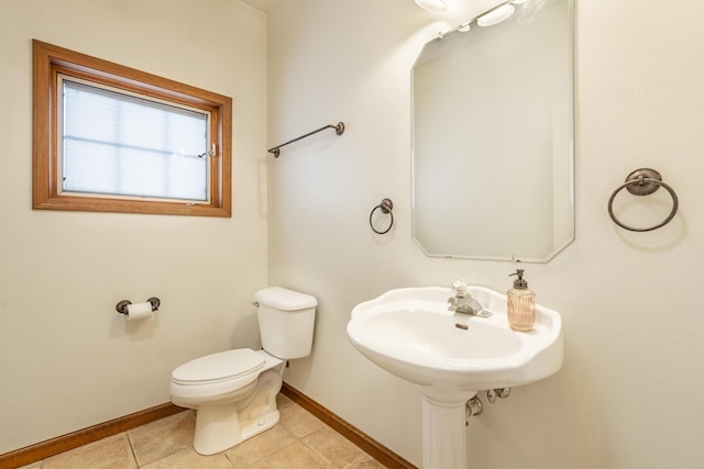 bathroom with toilet, tile patterned floors, and sink