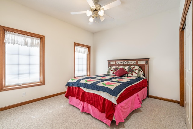 carpeted bedroom featuring ceiling fan and multiple windows