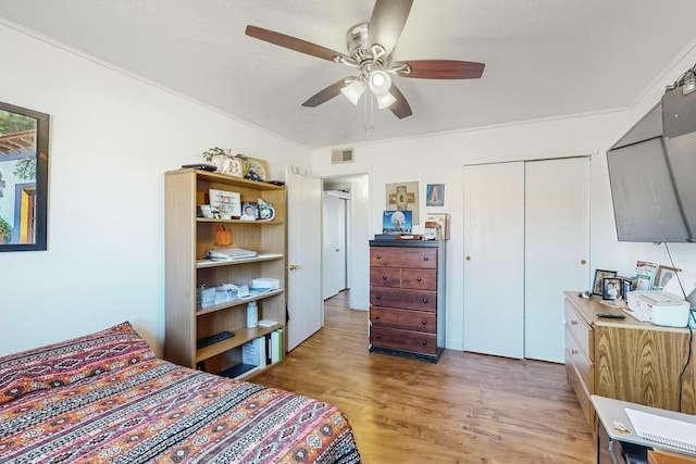 bedroom featuring ceiling fan, light hardwood / wood-style floors, crown molding, and a closet