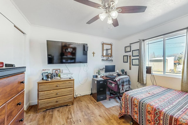 bedroom featuring light hardwood / wood-style flooring, ceiling fan, and crown molding