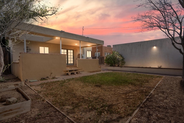 exterior space featuring stucco siding and fence