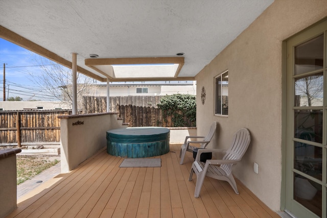 deck featuring fence and a covered hot tub