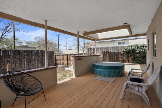 wooden deck featuring a fenced backyard and a covered hot tub