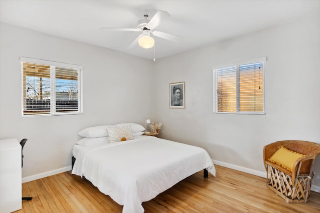 bedroom with multiple windows, ceiling fan, and light wood-type flooring