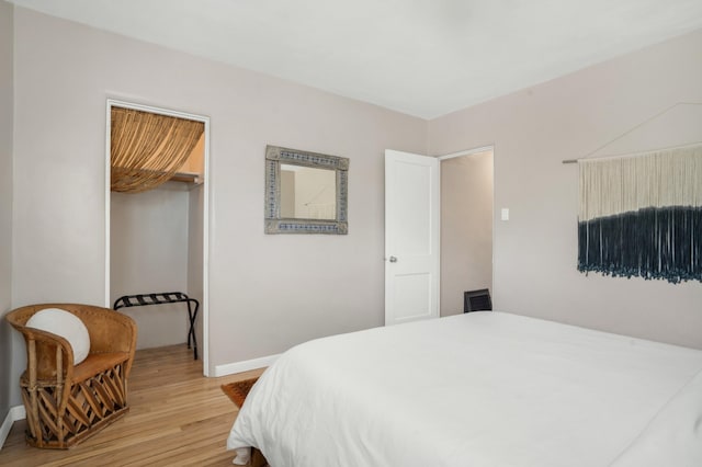 bedroom with baseboards, a closet, and light wood-style flooring