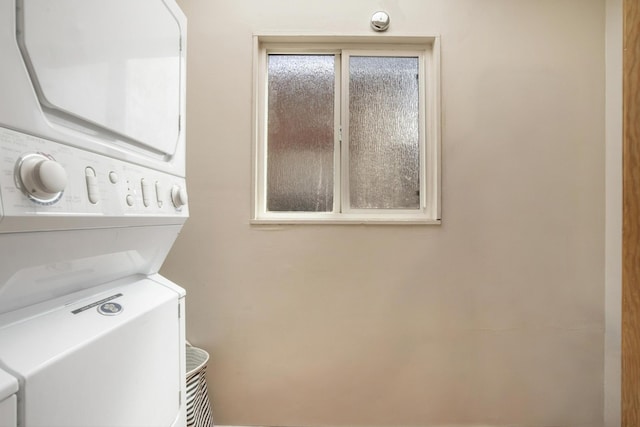 clothes washing area with stacked washer and dryer and laundry area