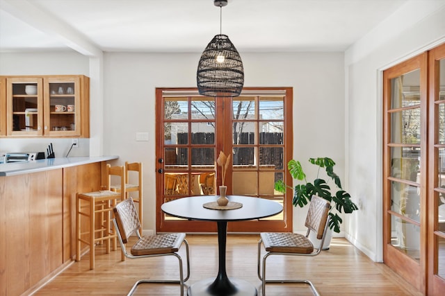 dining room featuring a notable chandelier, light wood-type flooring, and french doors