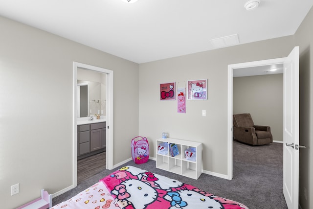 bedroom with connected bathroom, dark carpet, and sink