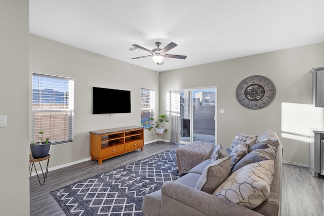 living room with ceiling fan and dark wood-type flooring