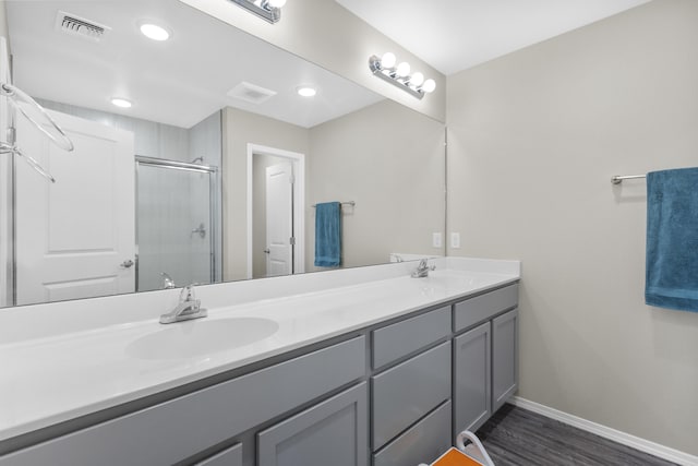 bathroom with a shower with shower door, wood-type flooring, and vanity