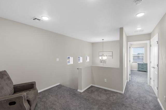 interior space with a chandelier and dark carpet