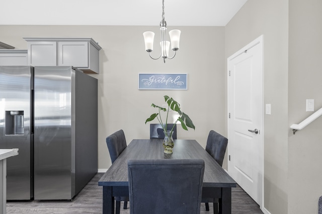 dining area featuring dark wood-type flooring and a chandelier