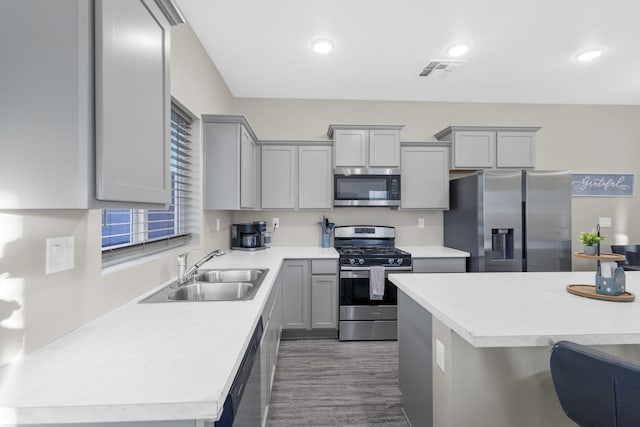 kitchen featuring dark hardwood / wood-style flooring, gray cabinets, sink, and stainless steel appliances