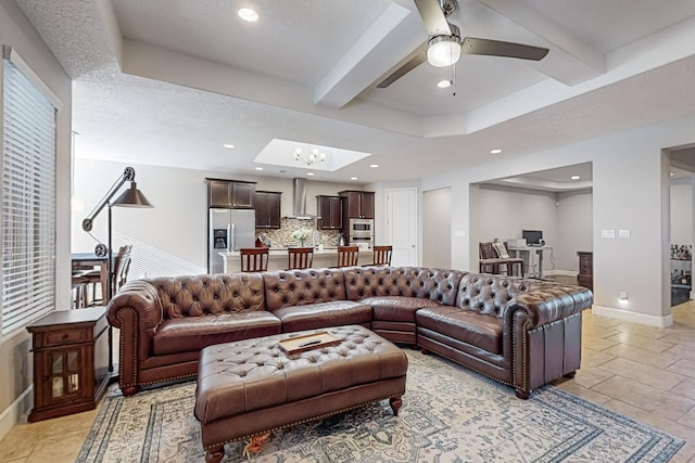 living room with beamed ceiling, ceiling fan, and a textured ceiling