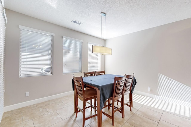 tiled dining area with a textured ceiling