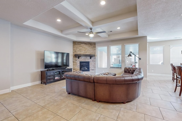 tiled living room featuring coffered ceiling, a stone fireplace, ceiling fan, a textured ceiling, and beamed ceiling