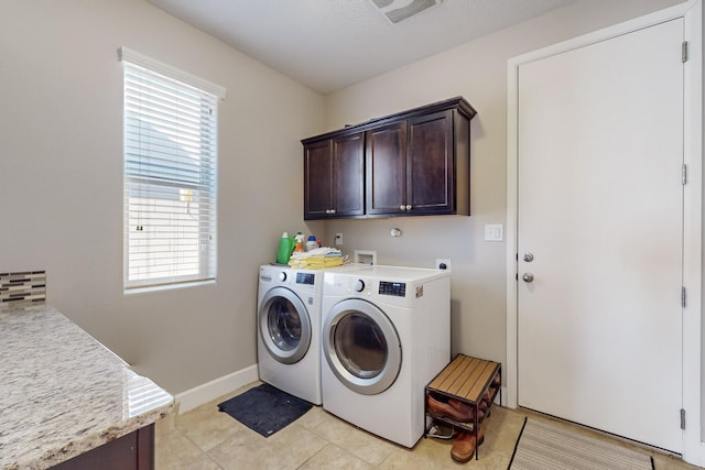 clothes washing area featuring independent washer and dryer, cabinets, light tile patterned floors, and a textured ceiling